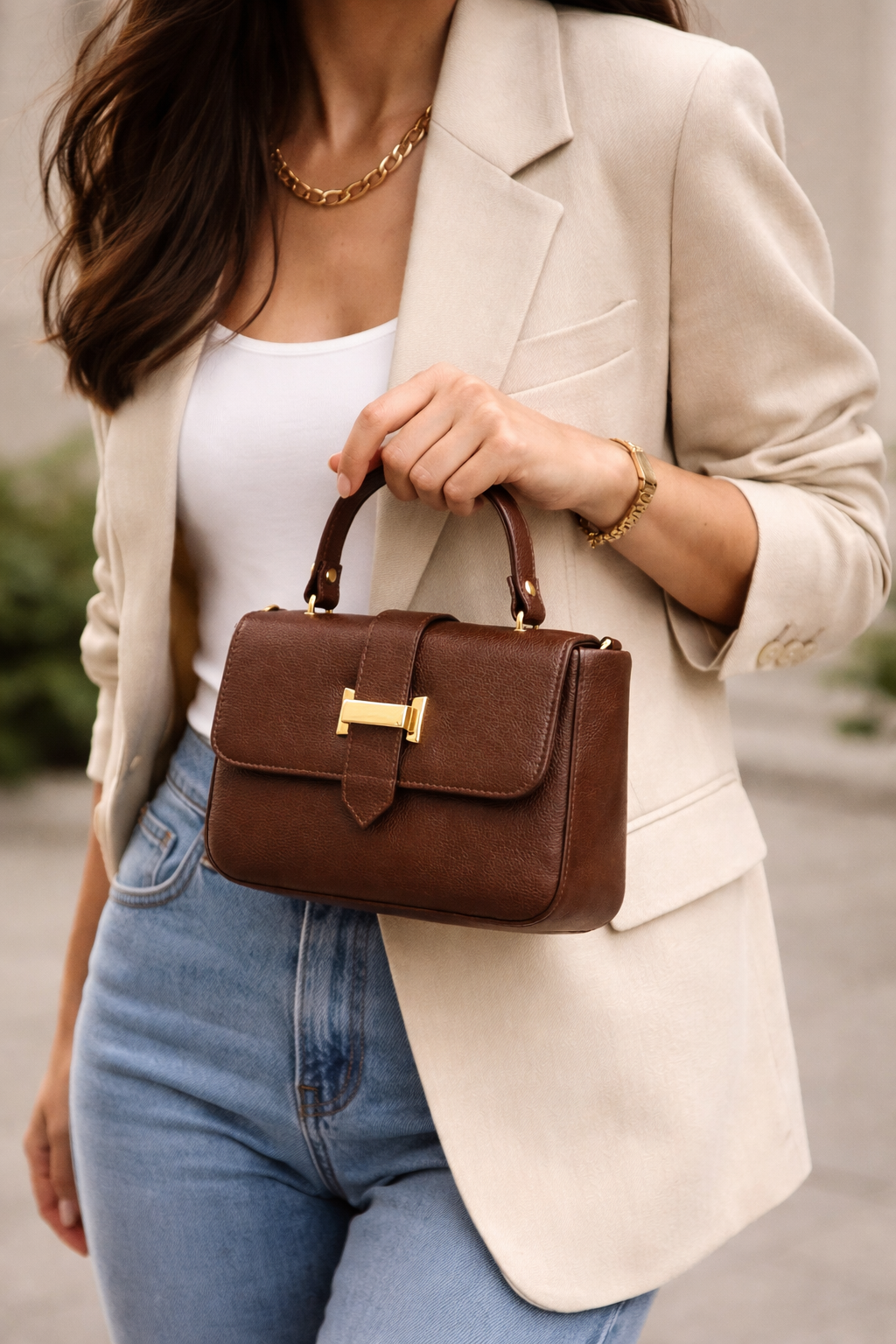 Bagistry The Essentialist Mini brown top-handle bag with gold lock, styled with model in blazer and jeans, polished everyday look